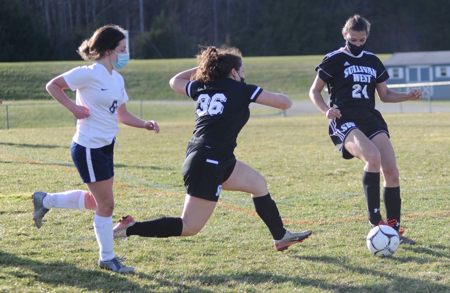 Sequential shot. Sullivan West’s Mia Nunari fires a late-game shot on goal as her teammate Anna Bernas sets it up, while Tri-Valley’s Clare Verbert tries to cut her off.